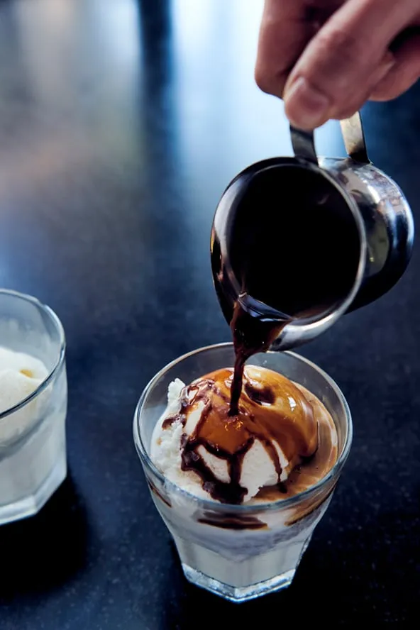 Espresso being poured over gelato.