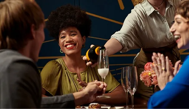 A group laughing and drinking cocktails.