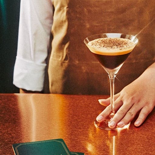 A bartender serves an espresso martini.