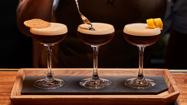 An espresso martini flight being garnished.