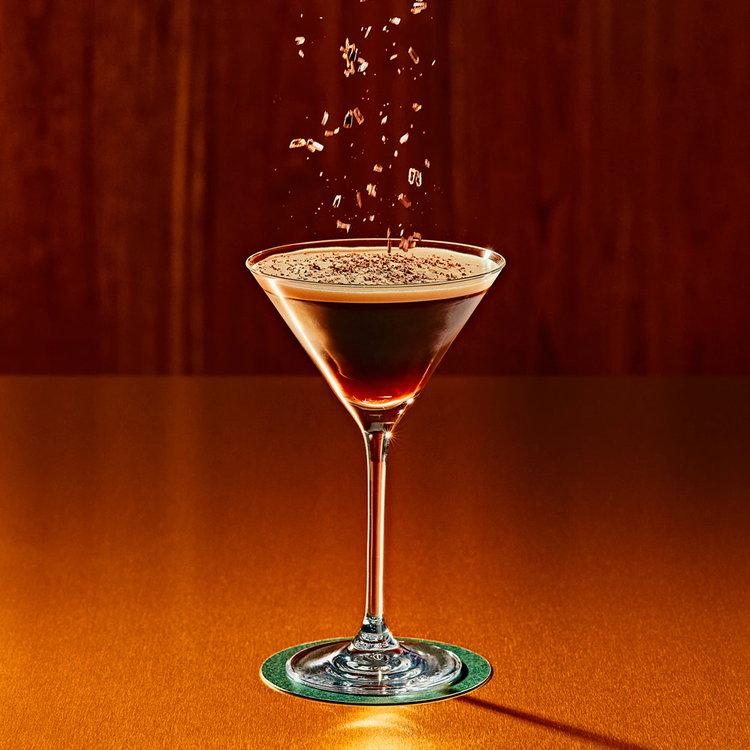 Garnish being sprinkled onto a martini.