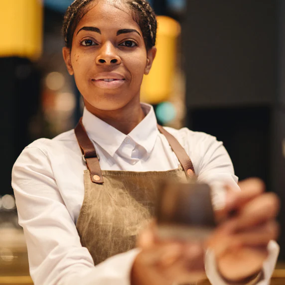 A partner presenting a cup of coffee.