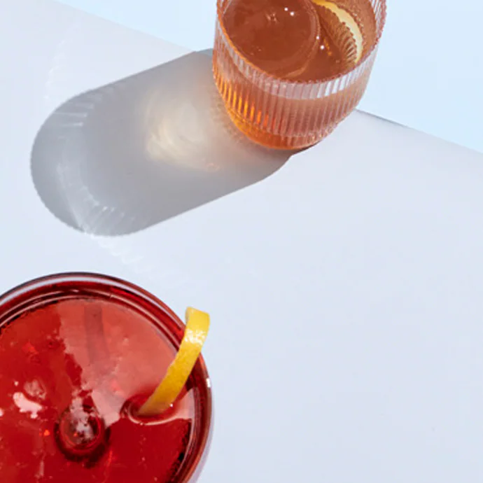 Two cocktails on a white surface.