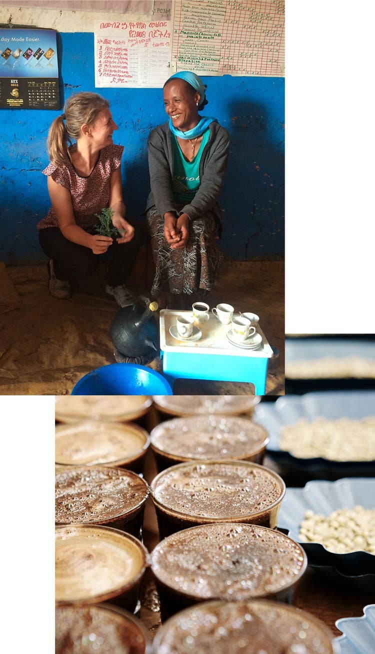 Two women laughing with coffee cups in front of them.