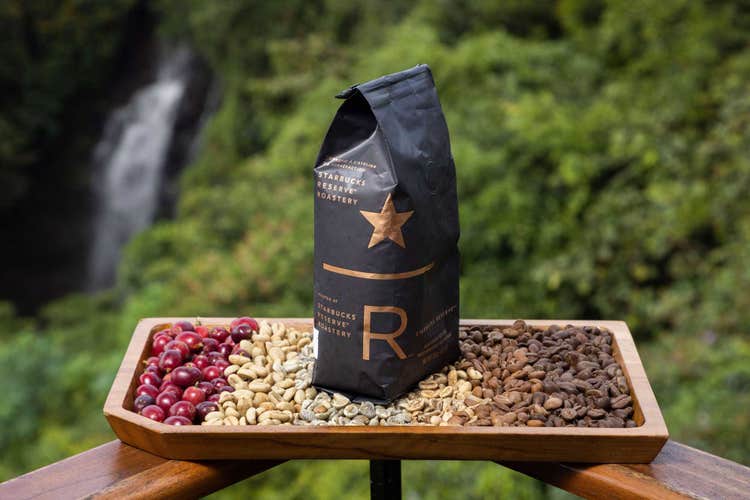 A bag of coffee sits atop raw coffee beans in the Costa Rican landscape.
