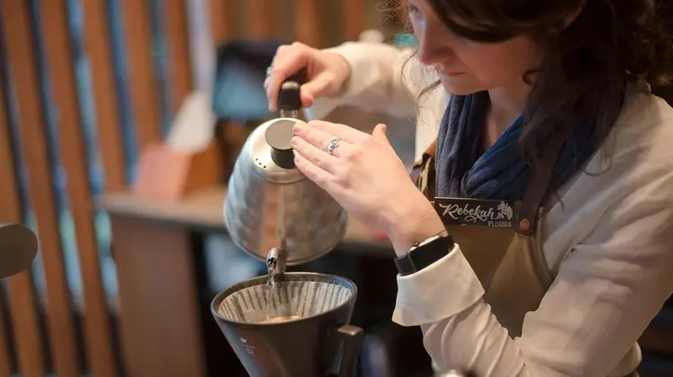 A partner brewing Chemex coffee.
